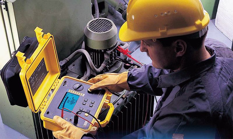 Revizní technik s přístrojem při měření izolačního odporu elektroinstalace
